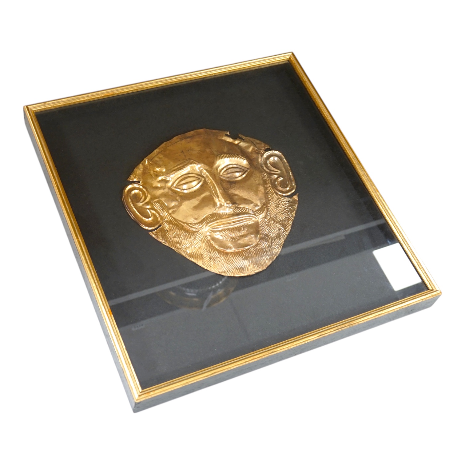 A museum type replica of an Agamemnon mask, copied from the gold mask of the king from the fifth Royal tomb on the Acropolis of Mycenae, 16th century B.C., made in Greece. Condition - good.